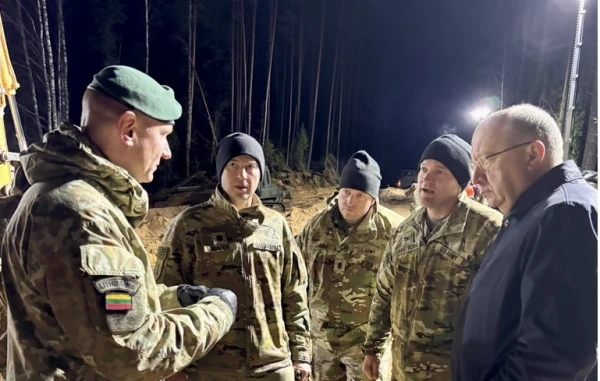 Изображение к статье: Ответственный за оборону Евросоюза - справа от своих военных.